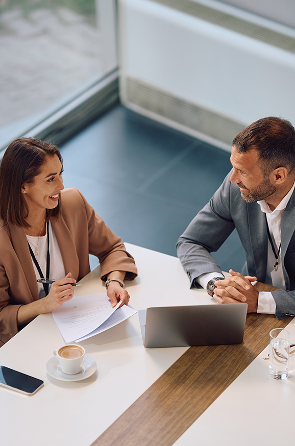 High,Angle,View,Of,Happy,Entrepreneur,And,Her,Colleague,Talking
